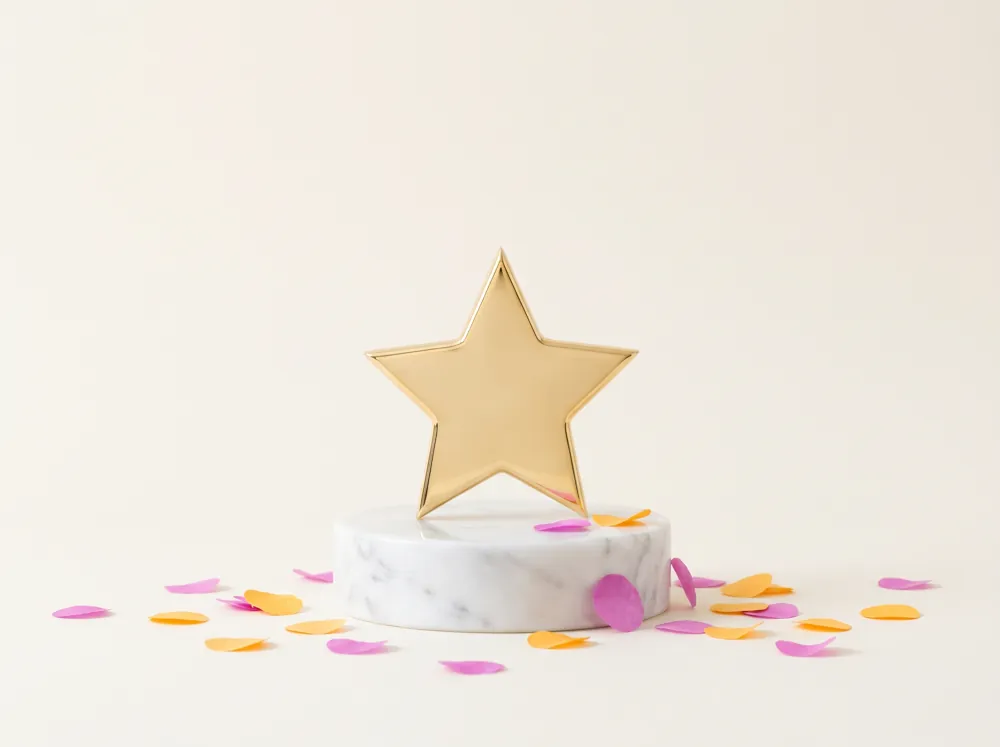 A golden star trophy on a marble plinth with magenta and marigold confetti