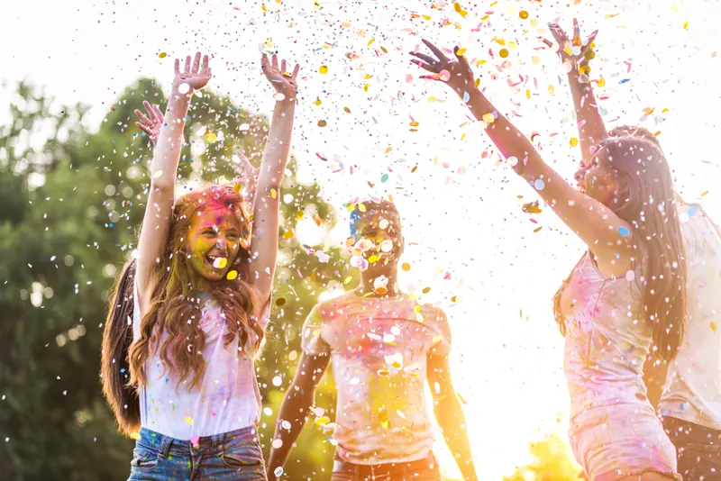 Friends celebrating in clouds of colour