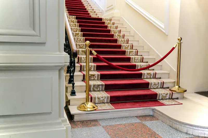 A red carpet staircase in a grand lobby