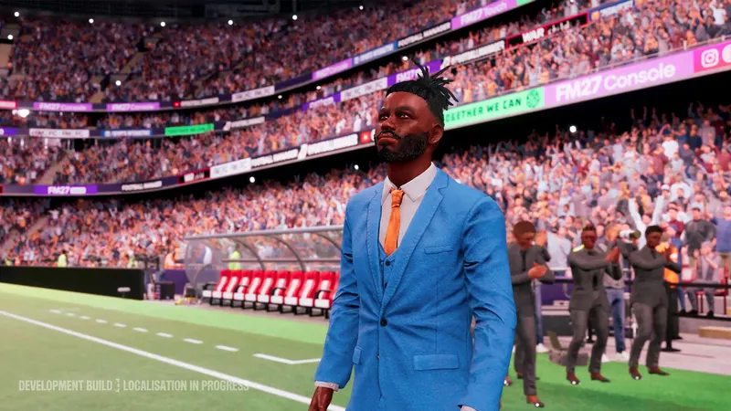 A manager in a blue suit standing on the touchline in a stadium