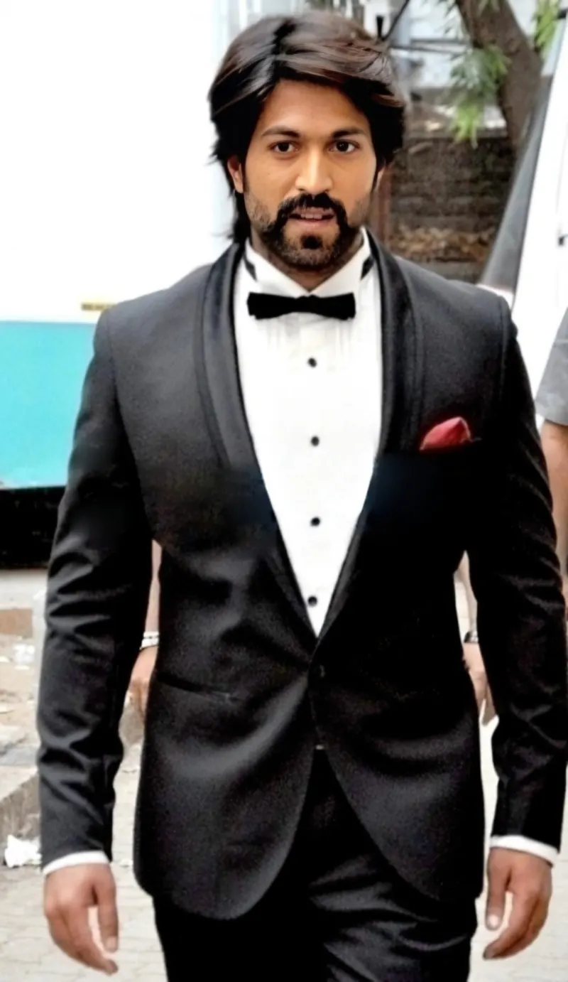 Yash in a black tuxedo and bow tie walking towards the camera