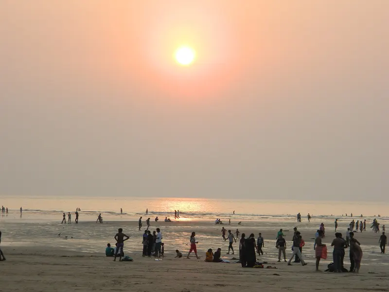 Sun setting over Aksa Beach with people on the sand
