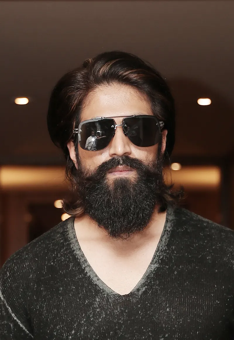 Yash with a full beard and dark sunglasses in a dark sweater