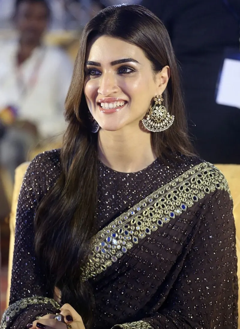 Kriti Sanon smiling in a dark embellished saree