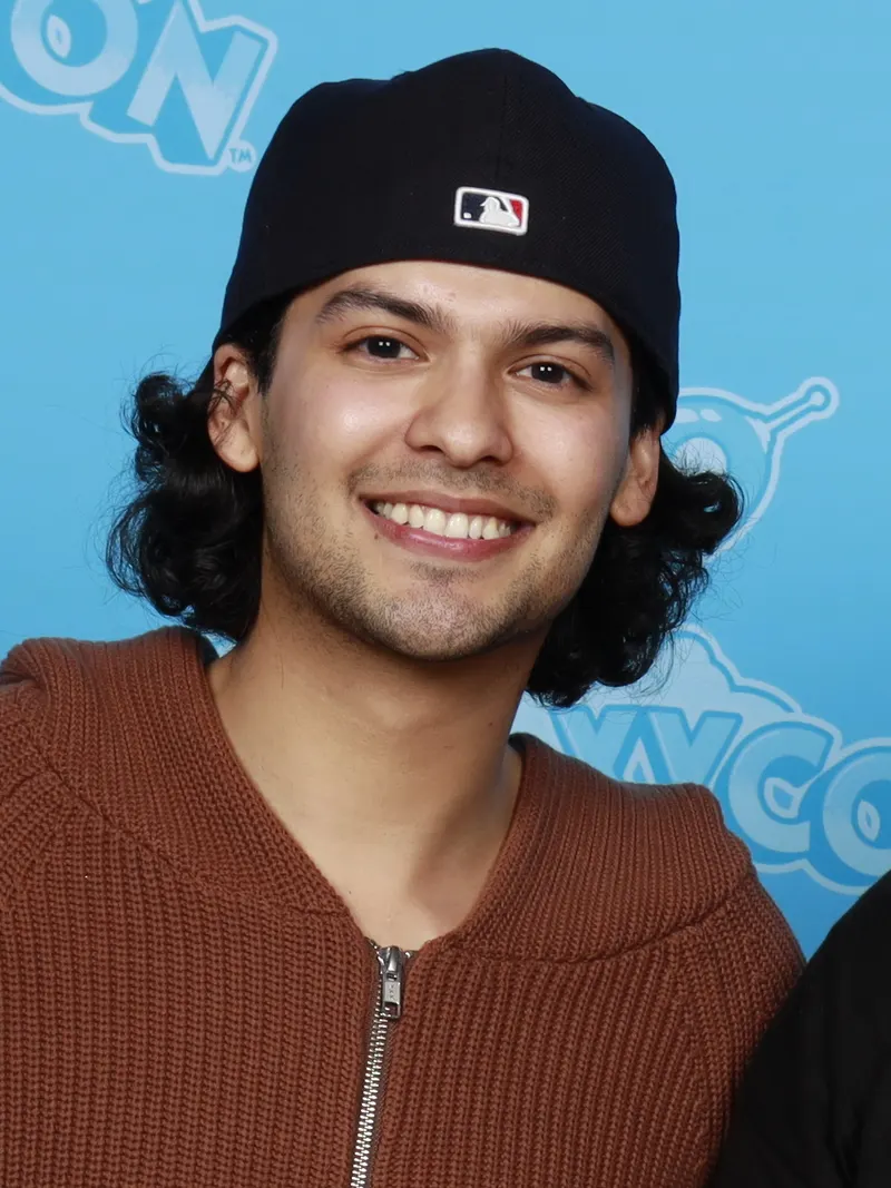 Xolo Maridueña smiling in a black cap