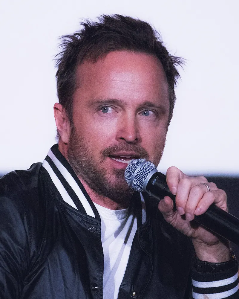 Aaron Paul speaking into a microphone