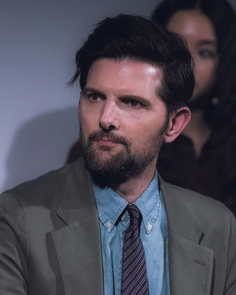 Adam Scott seated at a television panel