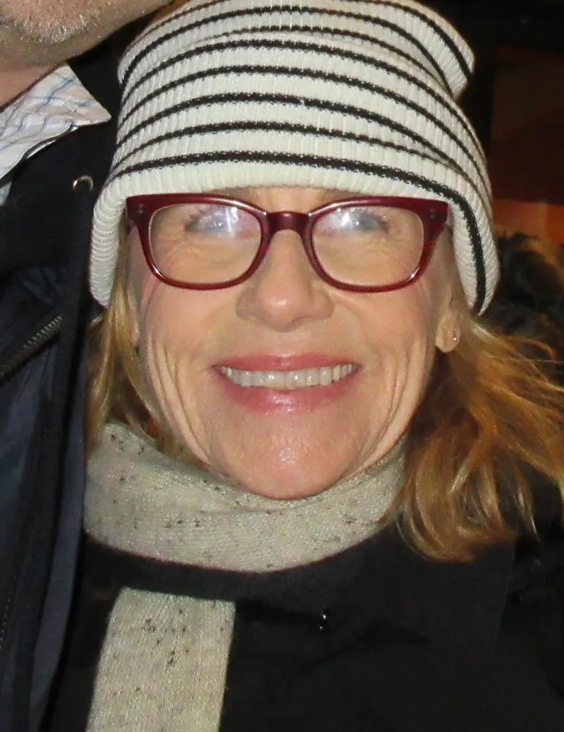 Amy Madigan in glasses and a striped beanie