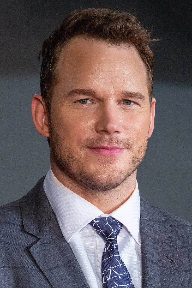 Chris Pratt in a suit and tie on a red carpet