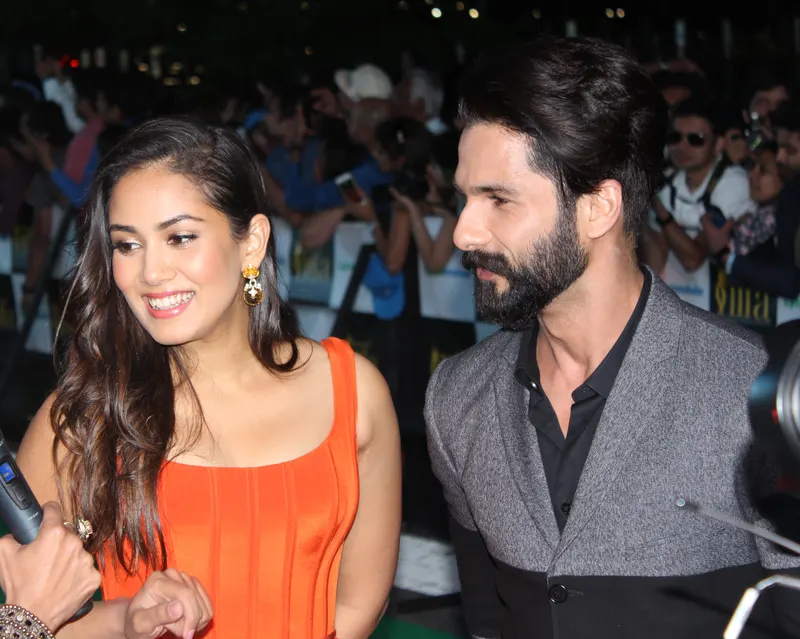 Mira Rajput smiling beside Shahid Kapoor at an awards event