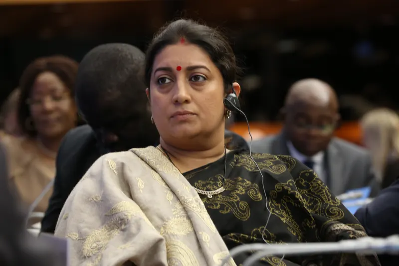 Smriti Irani in a black and gold saree at a conference