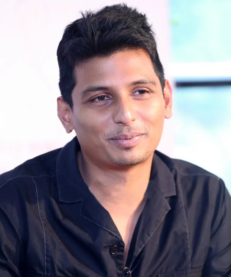 Jiiva smiling in a black shirt