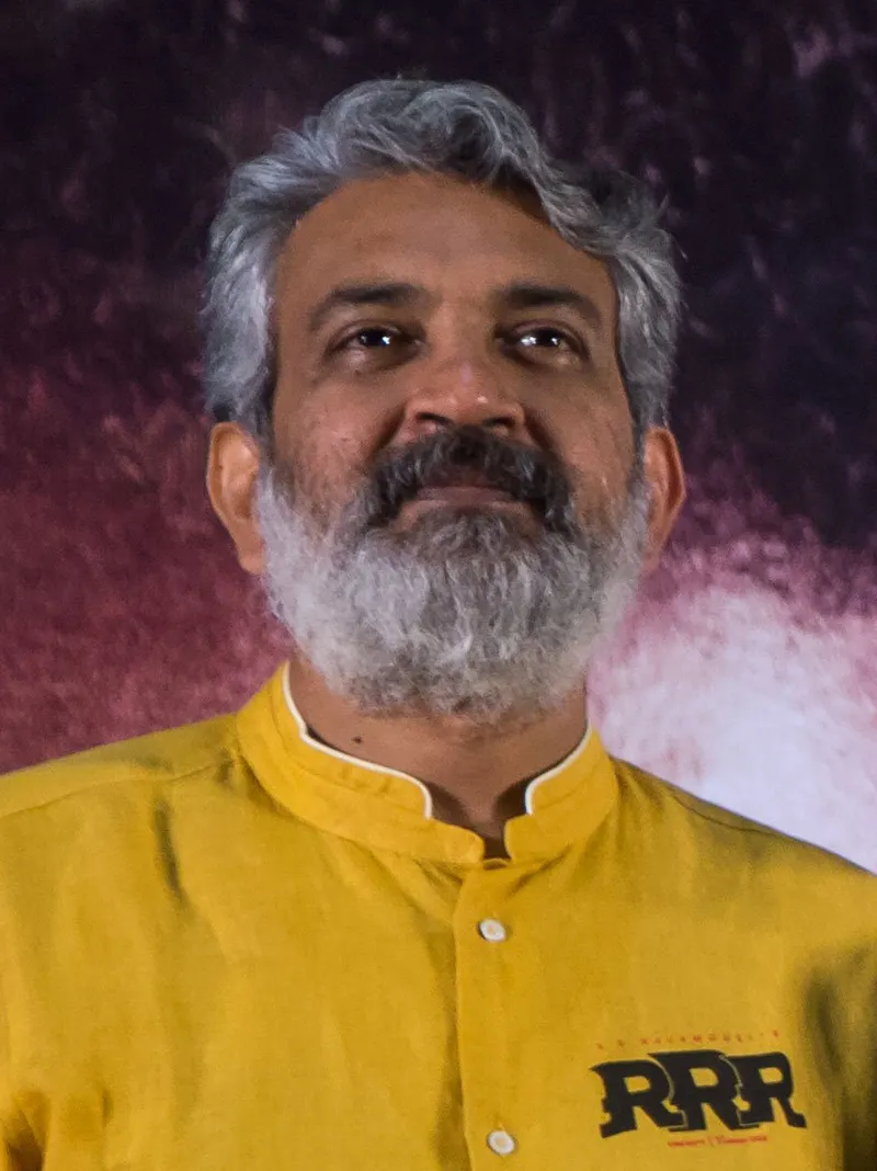 SS Rajamouli in a yellow shirt with a grey beard