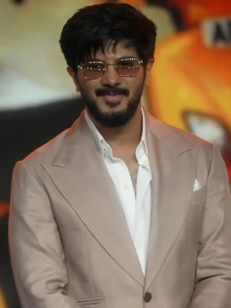 Dulquer Salmaan in a beige blazer and tinted glasses