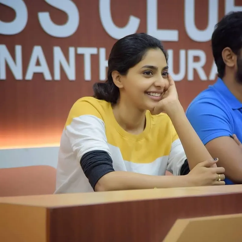 Aishwarya Lekshmi smiling with her chin resting on her hand