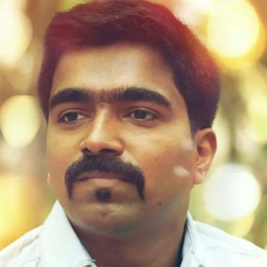 Ravi Basrur in a white shirt against a softly lit background