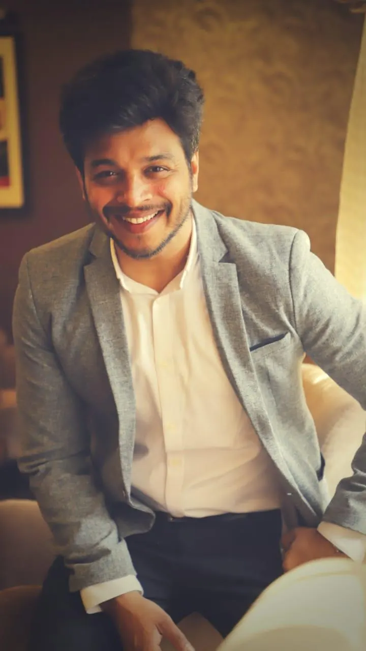 MG Srinivas smiling in a grey blazer