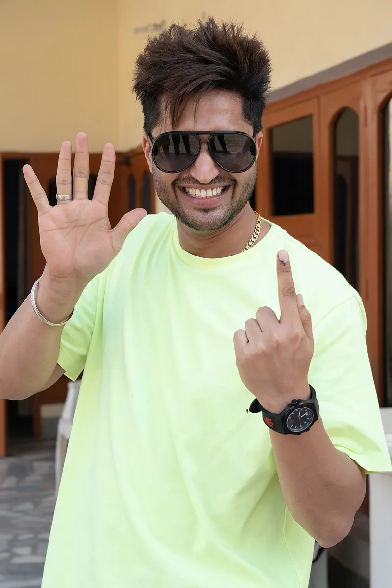 Jassie Gill smiling in sunglasses and a lime T-shirt