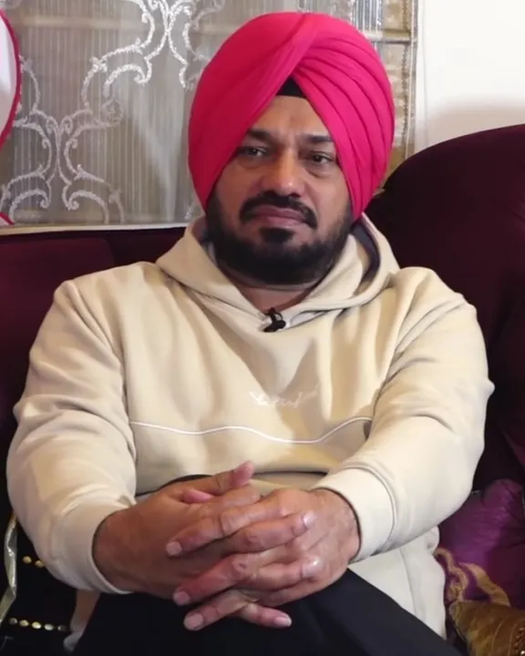 Gurpreet Ghuggi in a pink turban seated on a sofa
