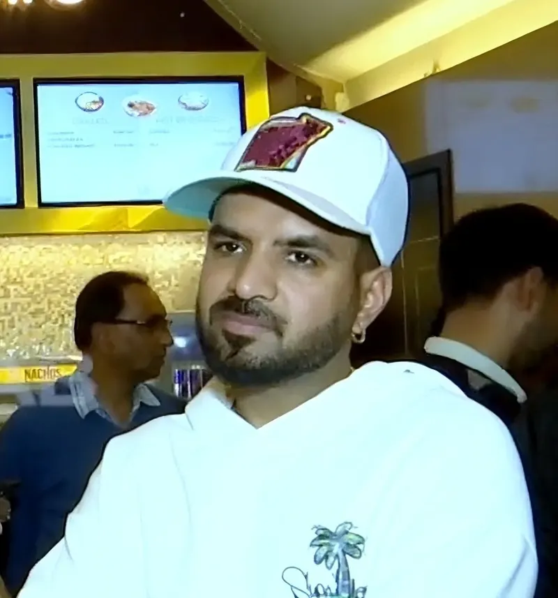 Happy Raikoti in a white cap and white top