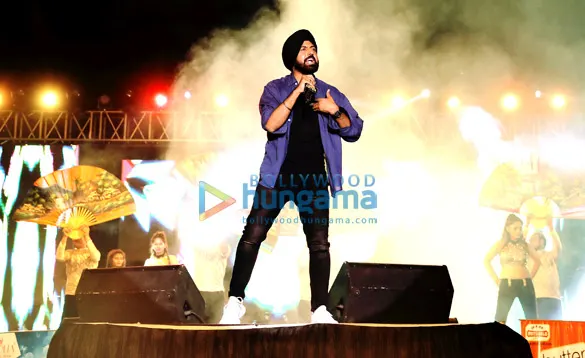 Gippy Grewal singing on stage with dancers behind him