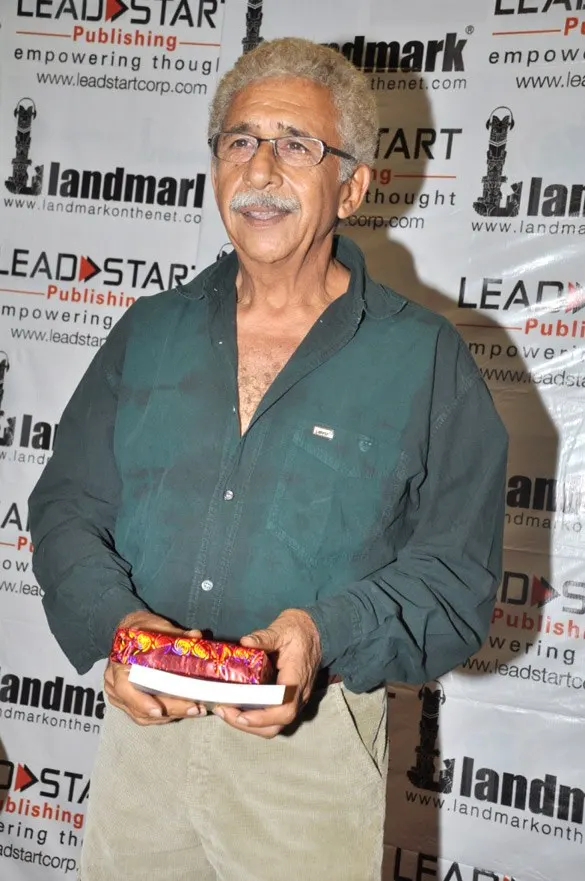 Naseeruddin Shah in a green shirt holding a gift
