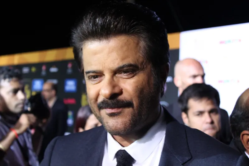 Close-up of Anil Kapoor in a suit on a green carpet