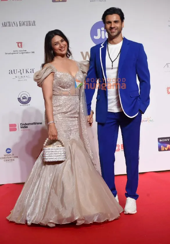 Divyanka Tripathi in a silver gown and Vivek Dahiya in a blue suit on a red carpet
