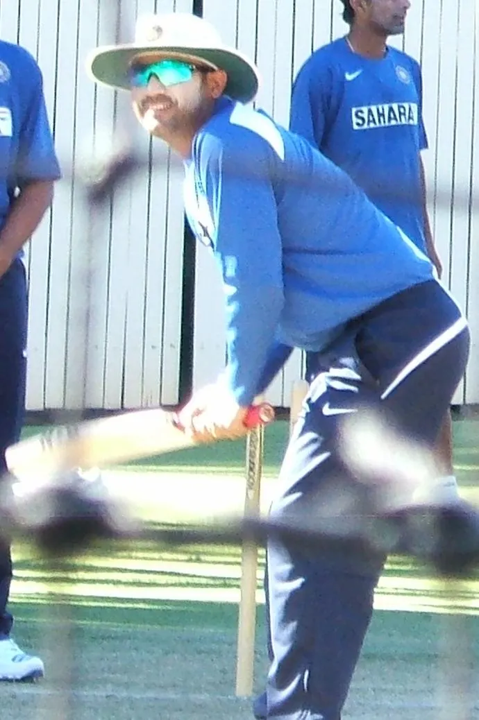 Virender Sehwag in a sun hat practising a batting stroke