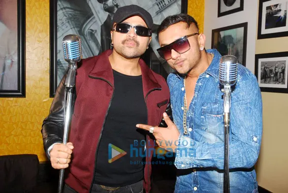 Himesh Reshammiya in a cap and sunglasses holding a vintage microphone