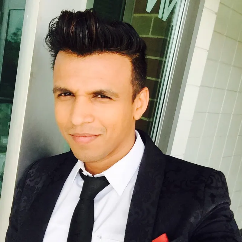 Abhijeet Sawant in a dark suit and tie smiling