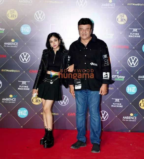 Anu Malik in a black shirt on a red carpet beside a guest