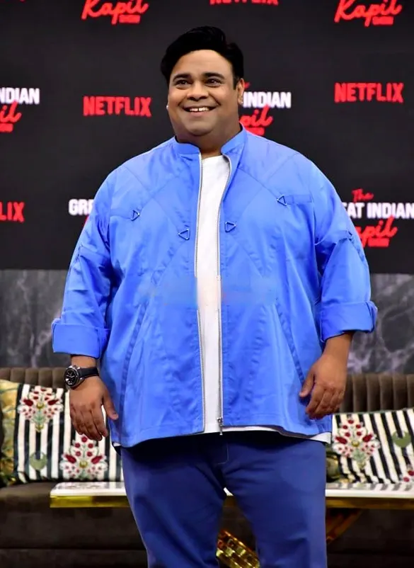 Kiku Sharda in a blue jacket at a press event