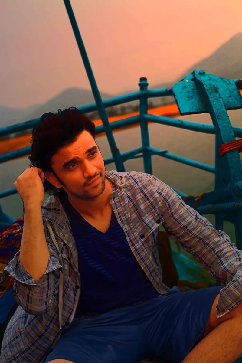 Rakesh Varre seated by a railing at sunset