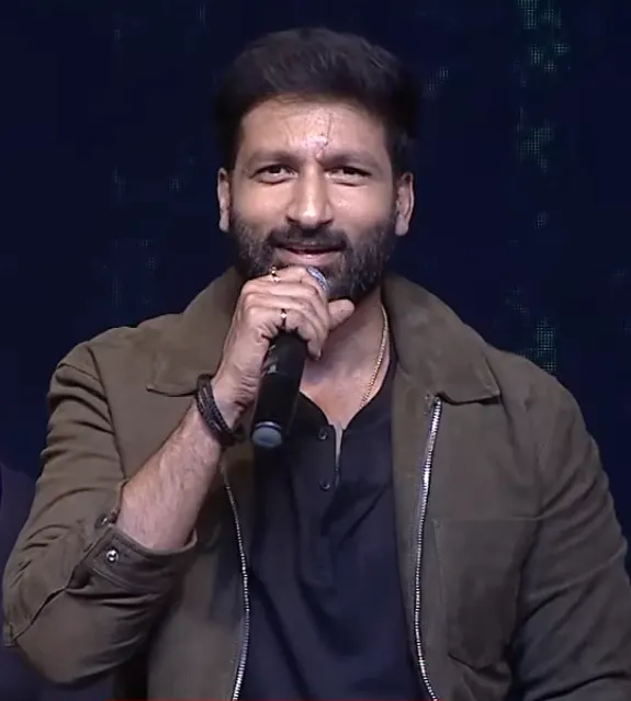 Gopichand speaking into a microphone on stage