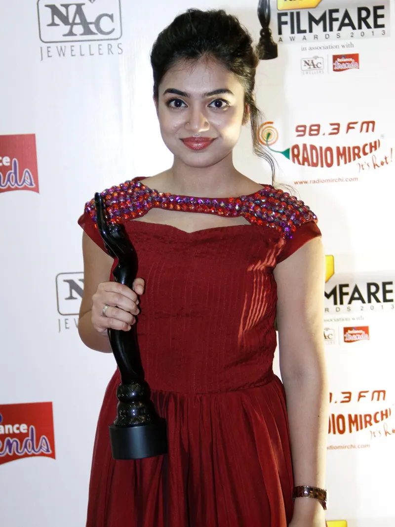 Nazriya Nazim in a red dress holding a Filmfare trophy