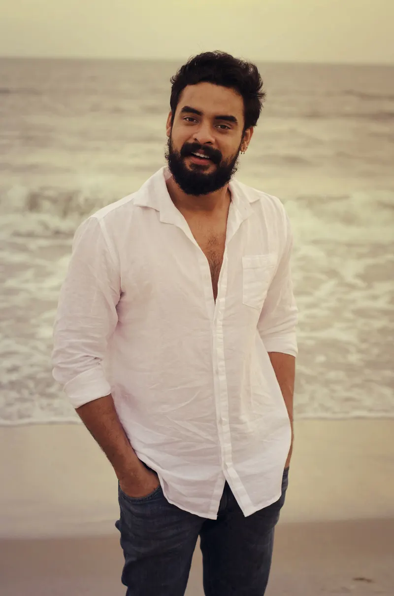 Tovino Thomas in a white shirt standing on a beach